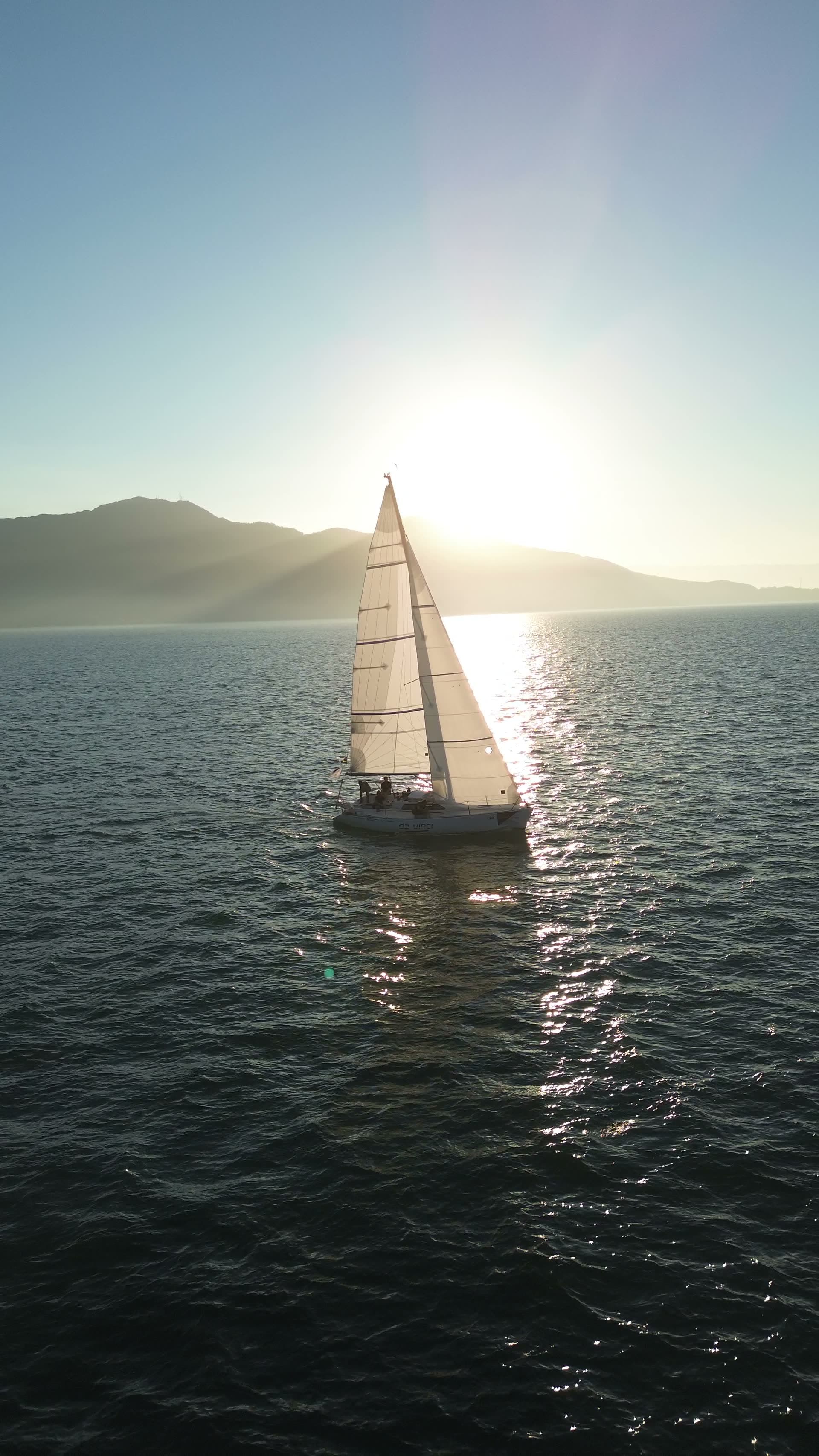 Veleiro ao pôr do sol captado com drone em Ilhabela